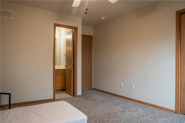 unfurnished bedroom featuring light carpet, baseboards, visible vents, a ceiling fan, and connected bathroom