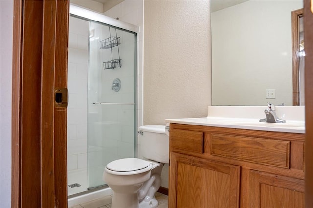 bathroom with toilet, a stall shower, a textured wall, and vanity