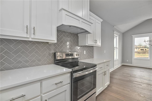 kitchen with white cabinetry, backsplash, electric range, custom range hood, and vaulted ceiling