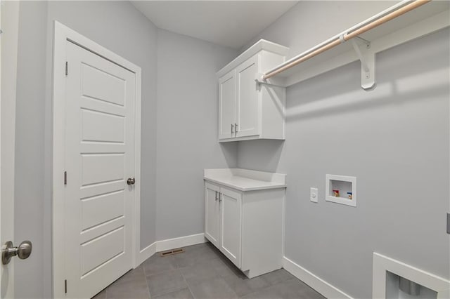 laundry room featuring light tile patterned flooring, cabinets, and washer hookup