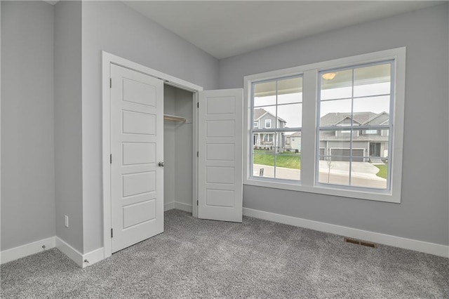 unfurnished bedroom featuring light carpet and a closet