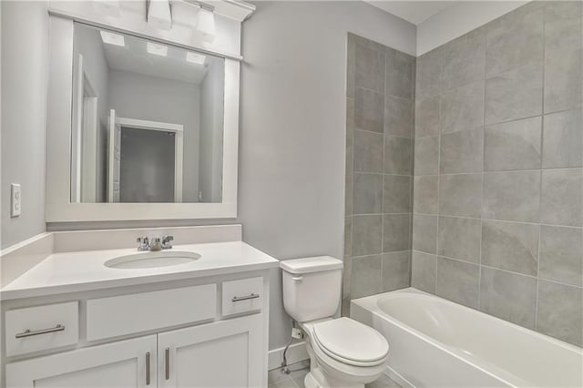 full bathroom with tiled shower / bath, vanity, and toilet