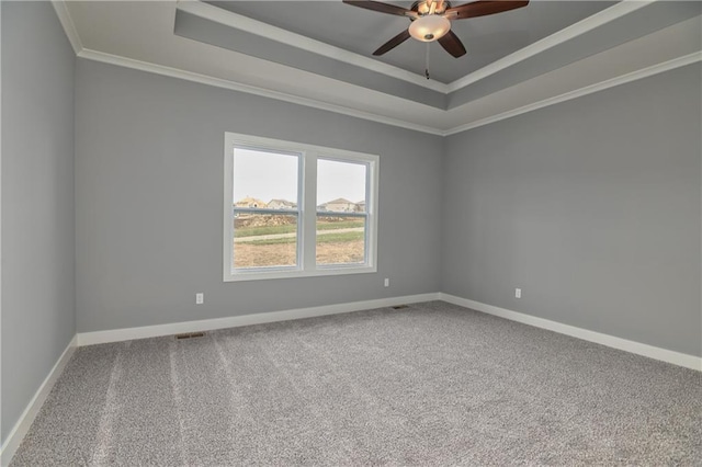 spare room with crown molding, carpet floors, a raised ceiling, and ceiling fan