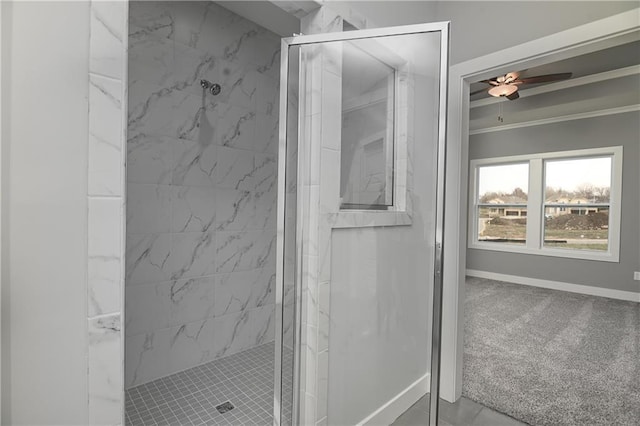 bathroom with ceiling fan, ornamental molding, and a tile shower