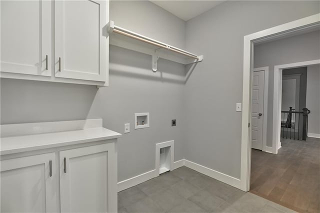 laundry room with electric dryer hookup, washer hookup, hardwood / wood-style floors, and cabinets