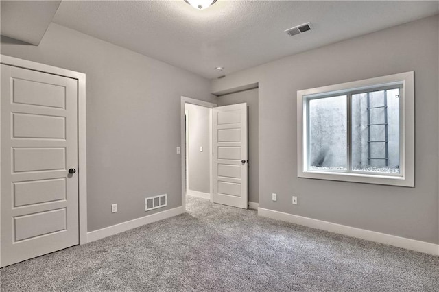 unfurnished bedroom featuring carpet floors and a textured ceiling