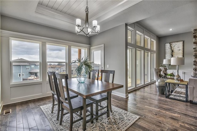 dining area featuring dark hardwood / wood-style floors and an inviting chandelier