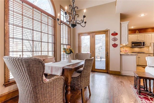 dining space featuring recessed lighting, baseboards, light wood-style floors, and a chandelier