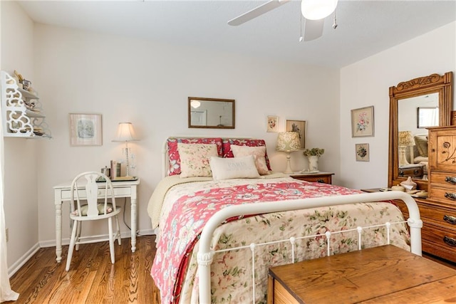 bedroom with ceiling fan, baseboards, and wood finished floors