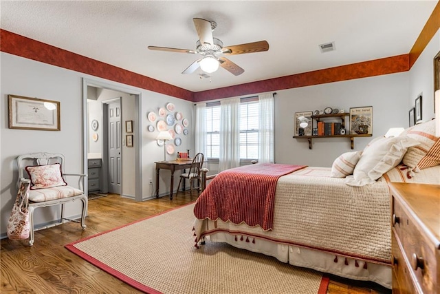 bedroom featuring ceiling fan, visible vents, and wood finished floors