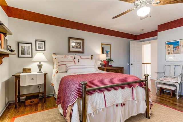 bedroom featuring baseboards, ceiling fan, and wood finished floors