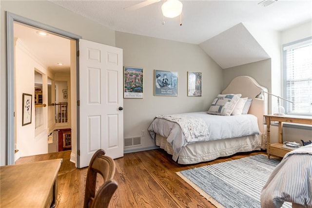 bedroom featuring lofted ceiling, wood finished floors, visible vents, and ceiling fan