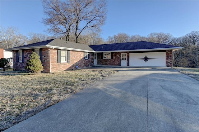 ranch-style house featuring a garage, concrete driveway, brick siding, and a front yard