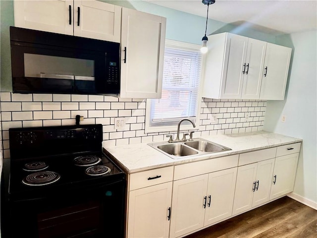 kitchen with hanging light fixtures, white cabinetry, sink, and black appliances