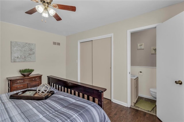 bedroom featuring dark wood-style flooring, a closet, visible vents, ceiling fan, and baseboards