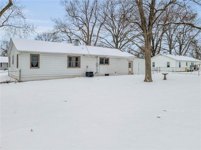 snow covered back of property featuring central air condition unit