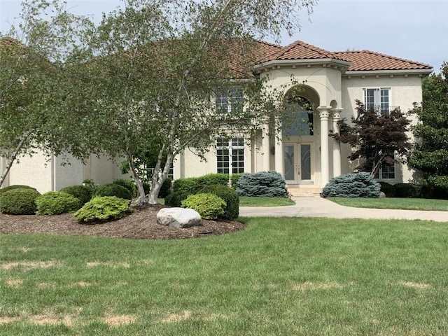 mediterranean / spanish-style house featuring a front lawn