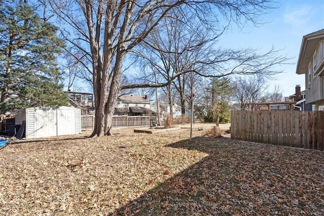 view of yard featuring an outbuilding, fence, and a shed