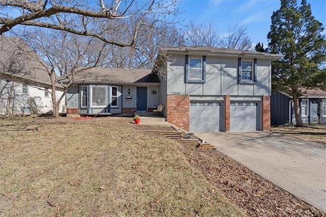 tri-level home featuring a garage, brick siding, and driveway