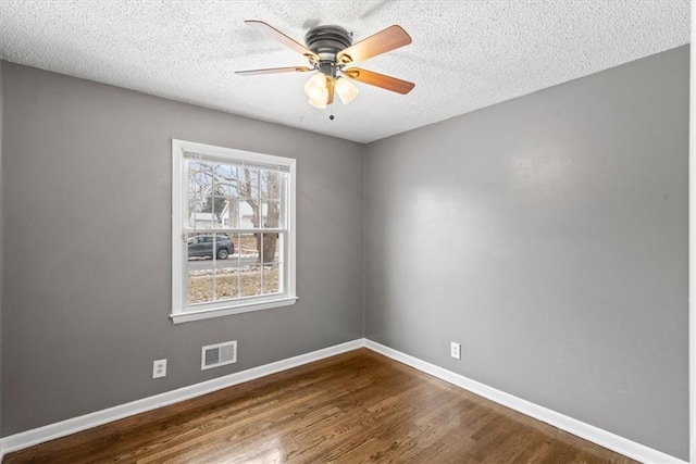 empty room featuring hardwood / wood-style flooring, ceiling fan, and a textured ceiling