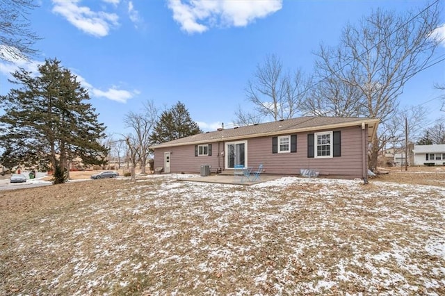 snow covered property featuring a patio area and central AC