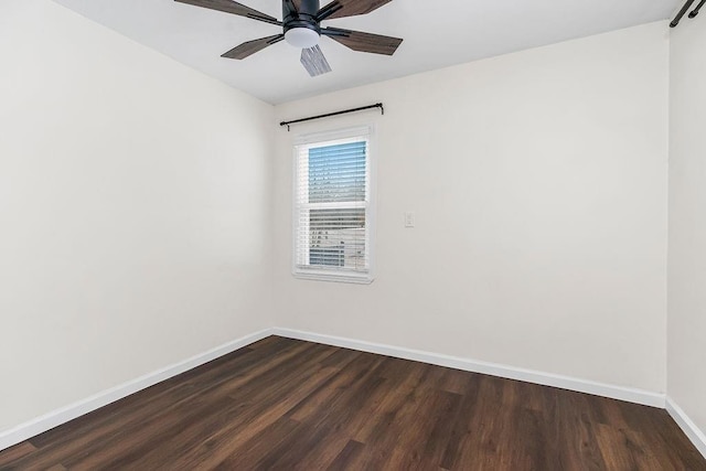 unfurnished room featuring baseboards, dark wood finished floors, and a ceiling fan