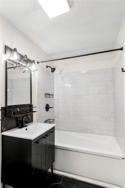 full bath featuring tile patterned flooring, vanity, and shower / bathing tub combination