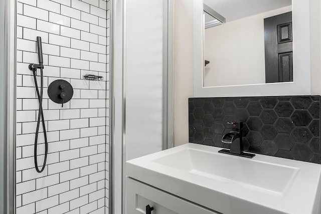 full bath with backsplash, a sink, and tiled shower