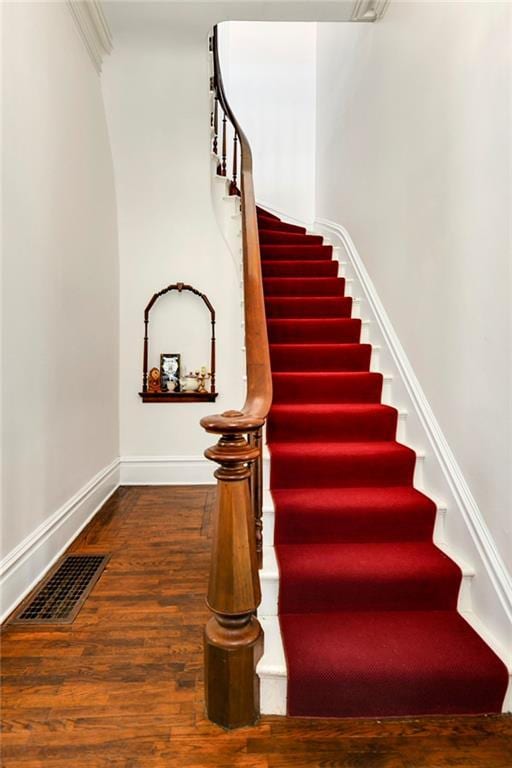 stairs featuring baseboards, visible vents, and wood finished floors