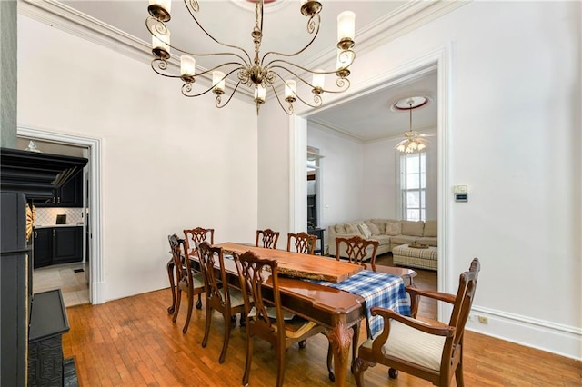 dining space with a chandelier, ornamental molding, and wood-type flooring