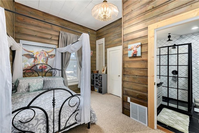 carpeted bedroom with visible vents, a notable chandelier, and wood walls