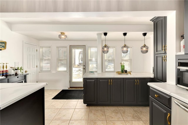 kitchen featuring hanging light fixtures, light tile patterned floors, light countertops, and dark cabinets