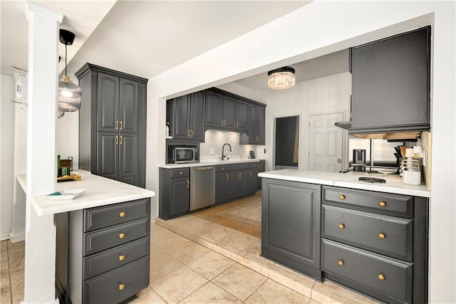 kitchen featuring pendant lighting, tasteful backsplash, light countertops, dishwasher, and a peninsula