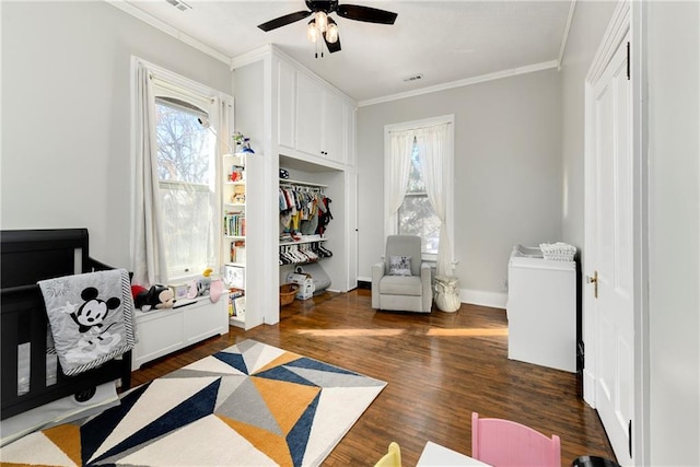 bedroom with a ceiling fan, visible vents, ornamental molding, and dark wood-style flooring