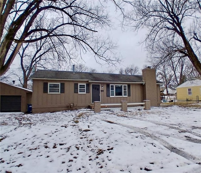 view of front of home with an outbuilding, a garage, board and batten siding, and a chimney