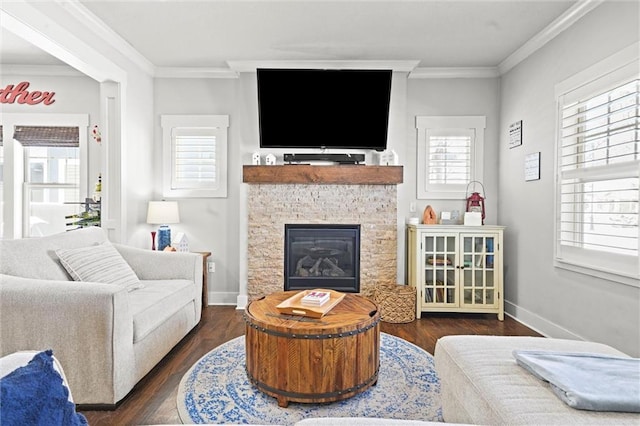 living room with dark wood-style floors, baseboards, a glass covered fireplace, and crown molding