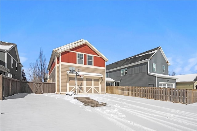 snow covered house with fence