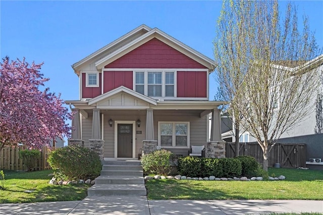 9011 NE 79th St, Kansas City, MO 64158 - craftsman inspired home featuring covered porch, stone siding, a front yard, and fence