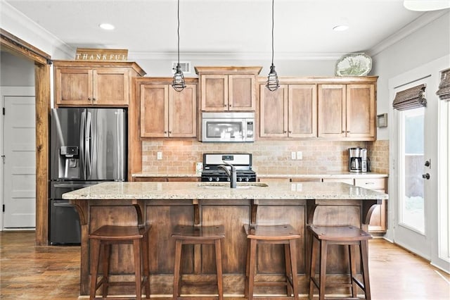 9011 NE 79th St, Kansas City, MO 64158 - kitchen featuring visible vents, an island with sink, appliances with stainless steel finishes, and crown molding