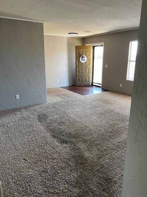 carpeted empty room with a textured ceiling