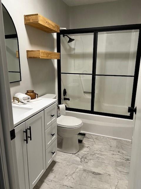 full bathroom with vanity, shower / bath combination with glass door, and toilet