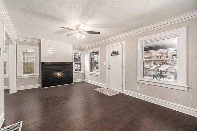 unfurnished living room with a textured ceiling, ornamental molding, dark hardwood / wood-style floors, and ceiling fan