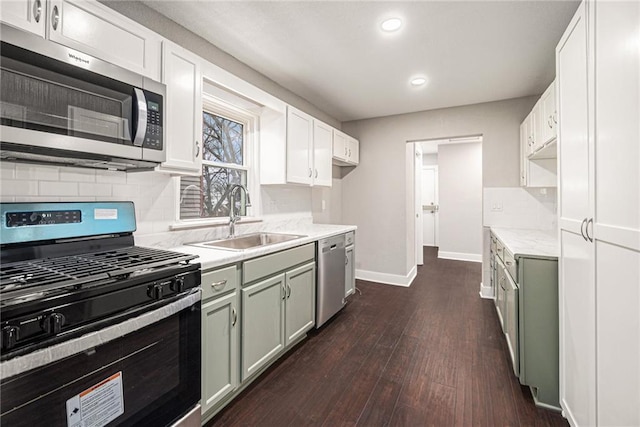 kitchen featuring white cabinets, green cabinets, stainless steel appliances, and sink