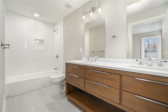 full bathroom with tiled shower / bath combo, vanity, and toilet