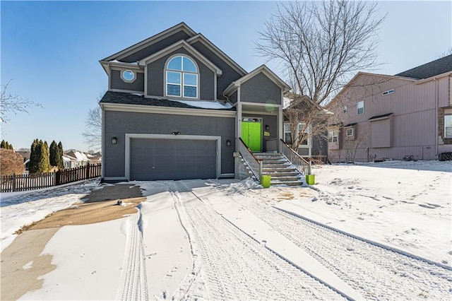 view of front of house featuring an attached garage, fence, and stucco siding