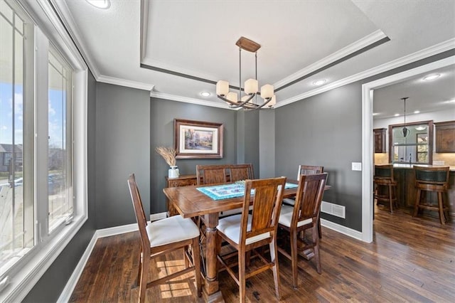 dining room with a tray ceiling, an inviting chandelier, and a wealth of natural light