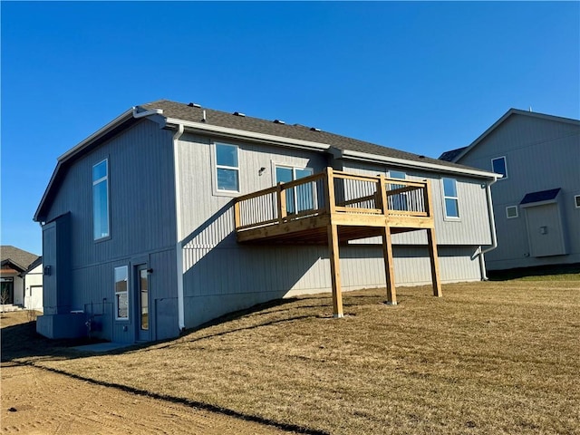 rear view of house featuring a deck and a lawn