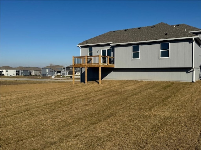 back of property with a deck and a lawn