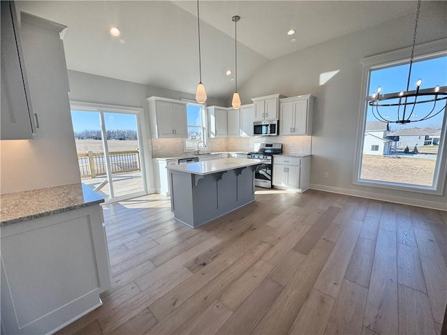 kitchen with sink, white cabinetry, tasteful backsplash, stainless steel appliances, and light hardwood / wood-style floors