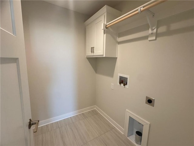 washroom with electric dryer hookup, hookup for a washing machine, and cabinets